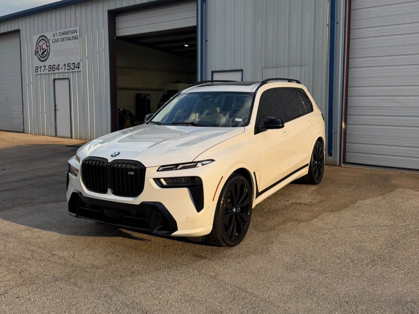 White BMW X7 with tinted windows parked in front of A1 Christian Car Detailing